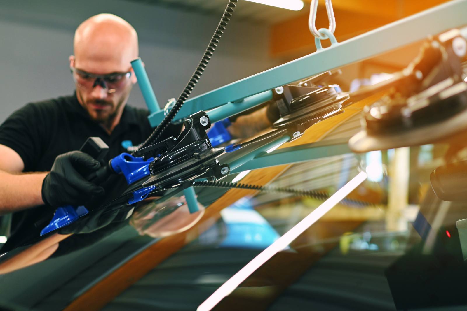 Technicien Uni Pare-Brise posant un pare-brise avec des ventouses de levage